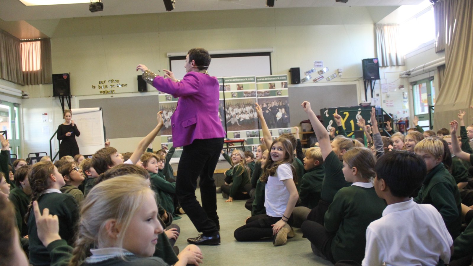 Young people taking part in an anti-bullying school workshop, with hands raised to contribute