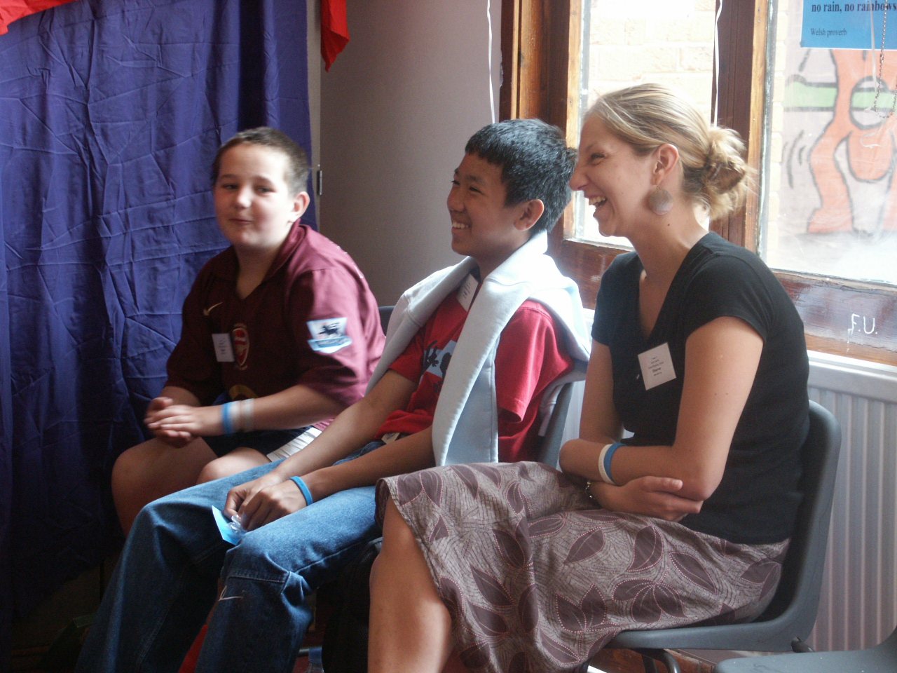 An adult and two young people talking and laughing together